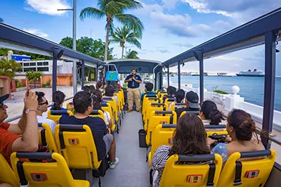 Passengers riding open-top bus, ocean view